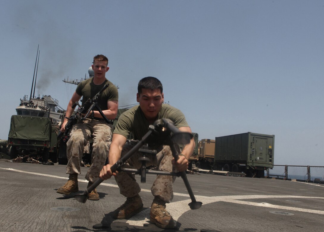 Lance Cpl. Eric T. Adams, left, a Flagler Beach, Fla., native, and Lance Cpl. Gregory A. Shindler, right, a Memphis, Tenn., native, machine gunners with Echo Company, Battalion Landing Team, 2nd Battalion, 2nd Marine Regiment, 22nd Marine Expeditionary Unit (MEU), rush to employ their M-240G machine gun during gun drills aboard dock landing ship USS Whidbey Island (LSD 41), Aug. 23, 2011. Gun drills provide machine gunners practice in moving with and employing their weapon system. The 22nd MEU is currently deployed as part of the Bataan Amphibious Ready Group (BATARG) as the U.S. Central Command theater reserve force, also providing support for maritime security operations and theater security cooperation efforts in the U.S. 5th Fleet area of responsibility.