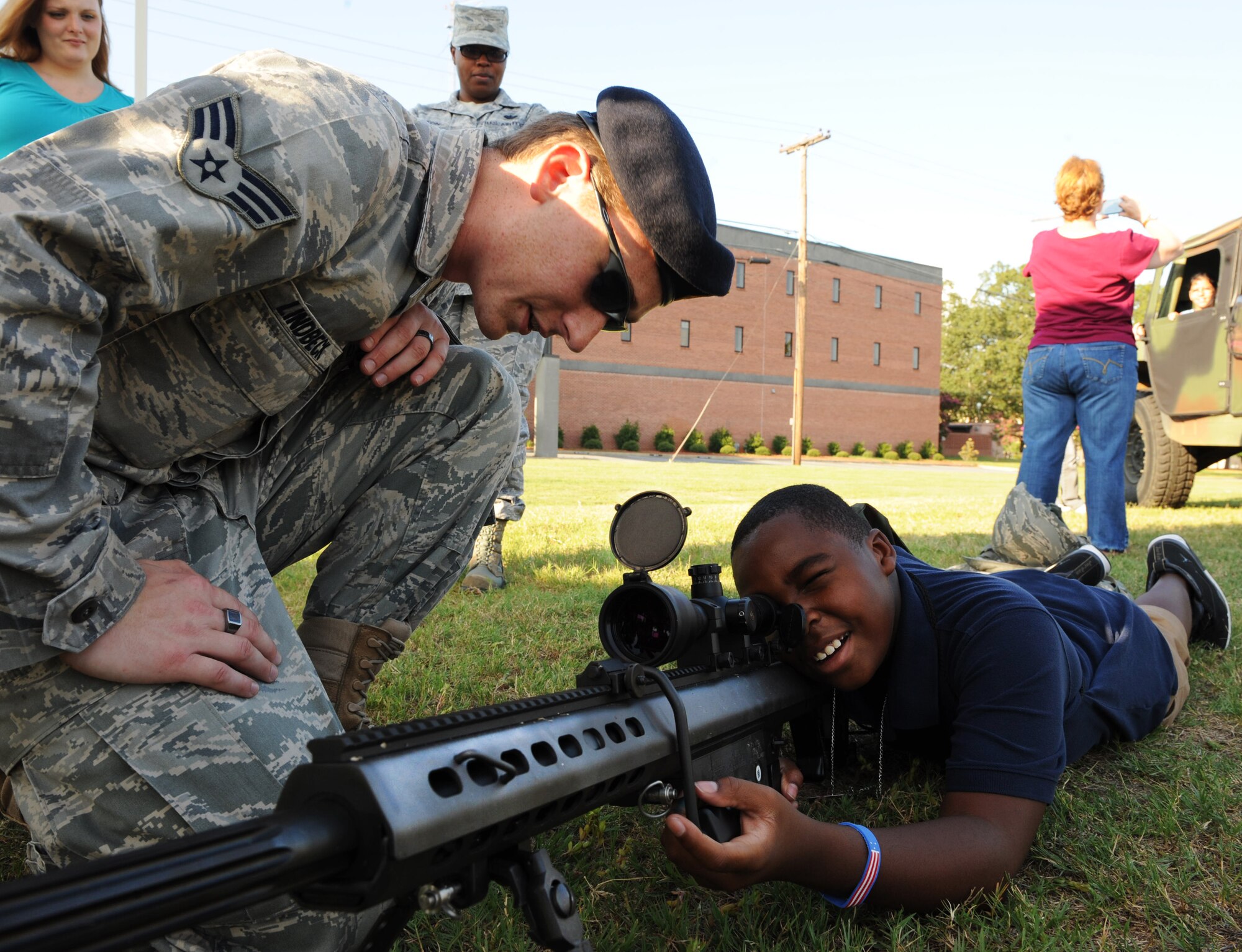 U.S. Air Force Senior Airman Jason Lindbeck, 20th Security Forces Squadron combat arms instructor, shows a son of U.S. Air Force Staff Sgt. Shamika Horton, 20th Operations Group knowledge operator, how to look through the scope of a M-107 Barrett-50 Caliber sniper rifle at Shaw Air Force Base, S.C. Aug. 24, 2011. Operation Take-Flight gives children a chance to experience what processes their parents go through prior to deployments. (U.S. Air Force photo/Airman 1st Class Tabatha L. Duarte)(Released)