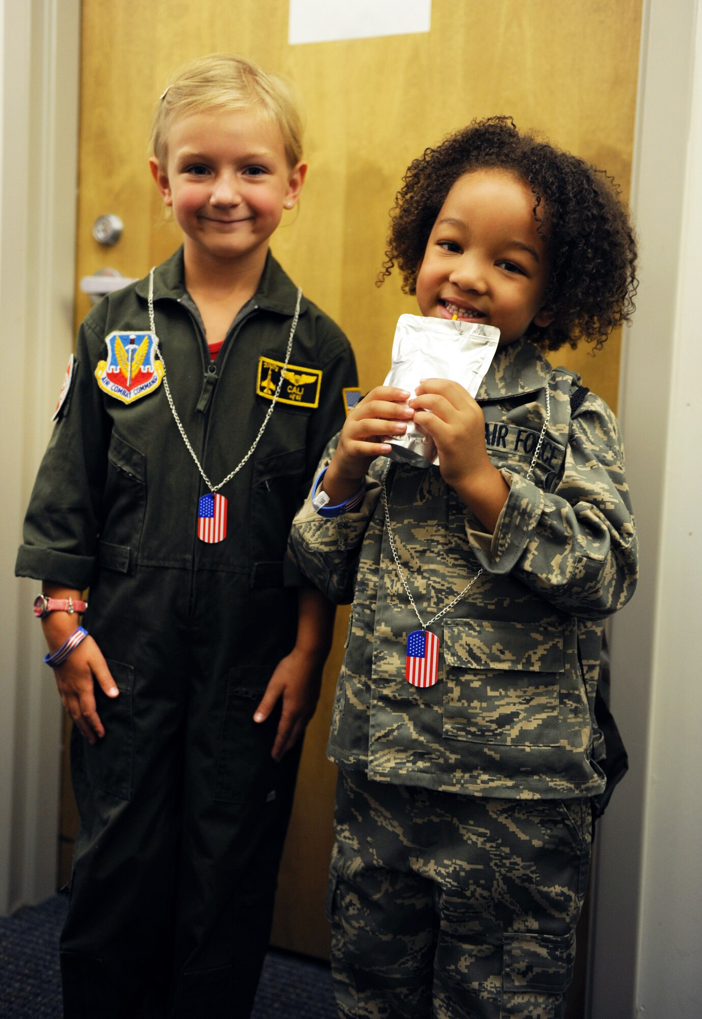 Cali Blodzinski, daughter of U.S. Air Force1st Lt. Ann Blodzinski, 20th Fighter Wing Chief of Public Affairs, and U.S. Air Force Capt. Jason Blodzinski, 77th Fighter Squadron F-16 Fighting Falcon pilot, and London Trammell, daughter of U.S. Air Force Staff Sgt. Akilah Trammell, 20th Logistics Readiness Squadron traffic management office, pose for a picture in their uniforms at the deployment processing center at Shaw Air Force Base, S.C. Aug. 24, 2011. Operation Take-Flight gives children a chance to experience what processes their parents go through prior to deployments. (U.S. Air Force photo/Airman 1st Class Tabatha L. Duarte)(Released)