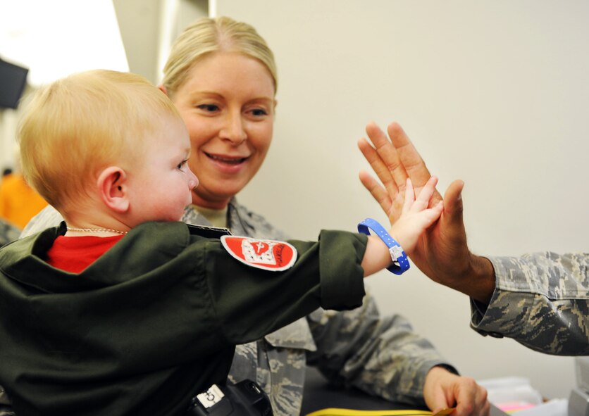Cade Blodzinski, son of U.S. Air Force 1st Lt. Ann Blodzinski, 20th Fighter Wing Chief of Public Affairs, and U.S. Air Force Capt. Jason Blodzinski, 77th Fighter Squadron F-16 Fighting Falcon pilot, gives a high-five at the deployment processing center on Shaw Air Force Base, S.C. Aug. 24, 2011. Operation Take-Flight gives children a chance to experience what processes their parents go through prior to deployments. (U.S. Air Force photo/Airman 1st Class Tabatha L. Duarte)(Released)