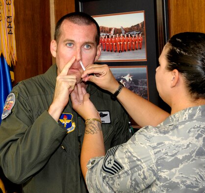 Lt. Col. Timothy Stong, left, the 71st Flying Training Wing director of staff, receives the FluMist influenza vaccine Aug. 24 from Tech. Sgt. Kelli Smith, NCO in charge of Pediatrics and Immunizations at the 71st Medical Group. Senior wing leadership and staff received the flu vaccines to kick off the 2011 flu vaccination drive at Vance AFB, Okla. (U.S. Air Force photo/ Roger Betz) 