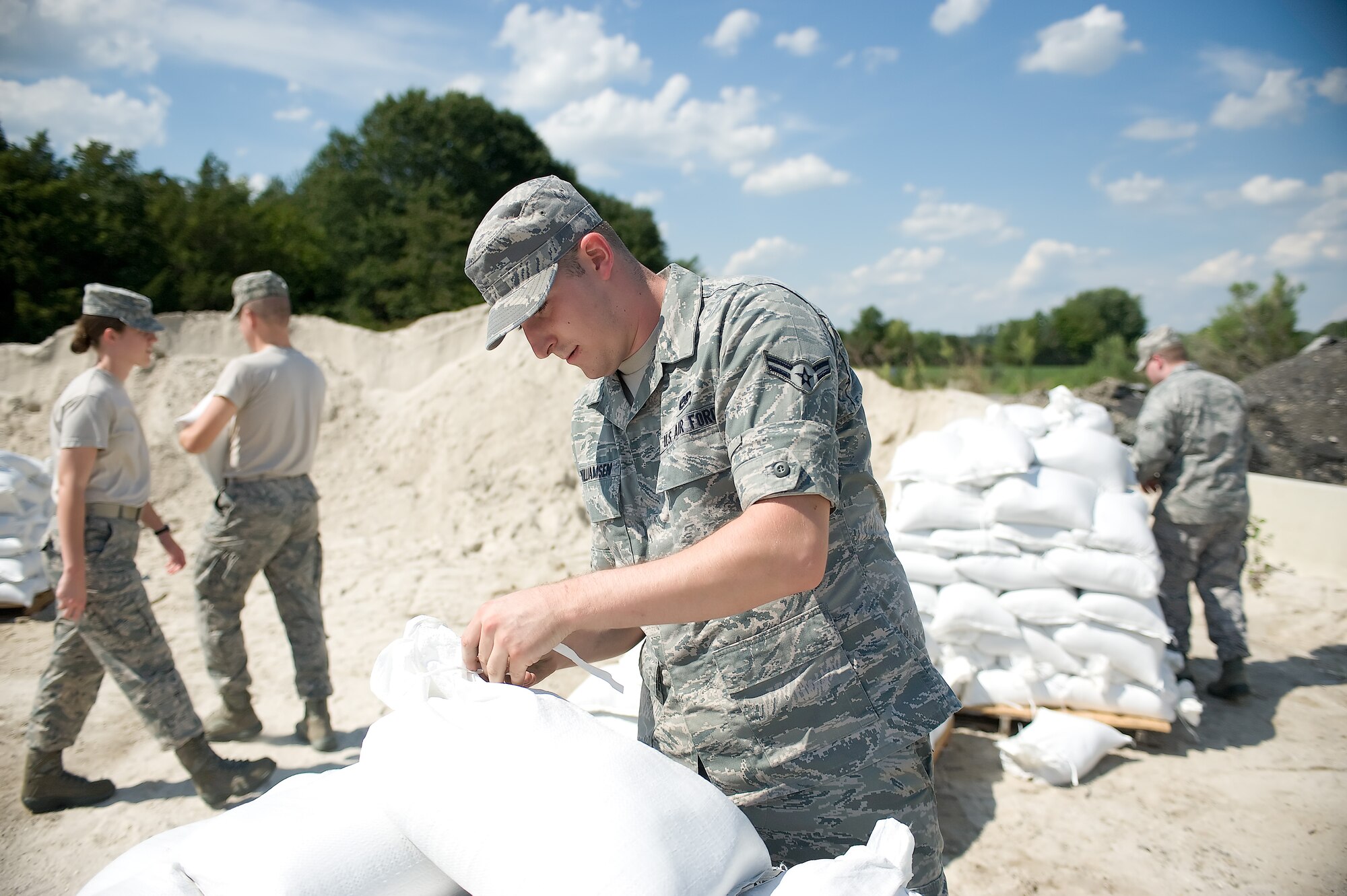 Airman 1st Class Chris Williamsen, an aerospace propulsion specialist with the 436th Maintenance Squadron, ties off a sandbag Aug. 24, 2011, at Dover Air Force Base, Del. Team Dover is preparing for the possible effects of Hurricane Irene. (U.S. Air Force photo by Steve Kotecki)