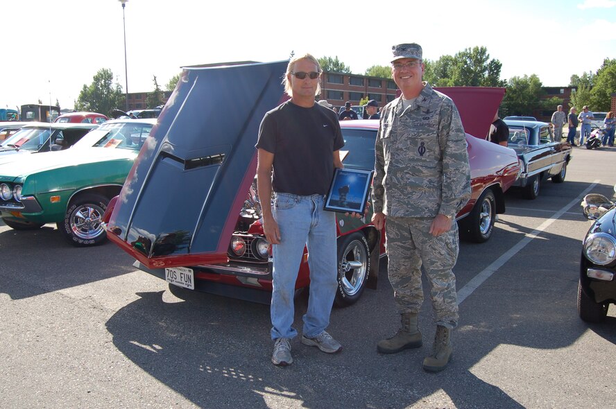 MINOT AIR FORCE BASE, N.D. – Col. Thomas A. Summers, 91st Missile Wing vice commander, presented Dana Peterson, the Rough Rider's Choice award during the 6th Annual Show and Shine Car Show held here Aug. 19. Wing leadership from the 5th Bomb Wing and 91st MW each select one vehicle they believe deserves recognition as that wing's Commander's Choice. Peterson’s vehicle, a 1970 Ford Torino, was the Commander's Choice pick. (Courtesy photo)

