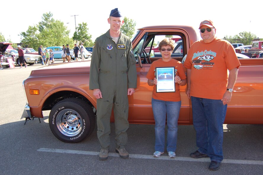 MINOT AIR FORCE BASE, N.D. -- Col. James Dawkins, 5th Bomb Wing commander, presented Lee Schoffstall and Marlene Schoffstall, the Warbird's Choice award during the 6th Annual Show and Shine Car Show held here Aug. 19. Wing leadership from the 5th BW and 91st Missile Wing each select one vehicle they believe deserves recognition as that wing's Commander's Choice. The Schoffstall vehicle, a 1972 GMC pick-up, was the Commander's Choice pick. (Courtesy photo)
