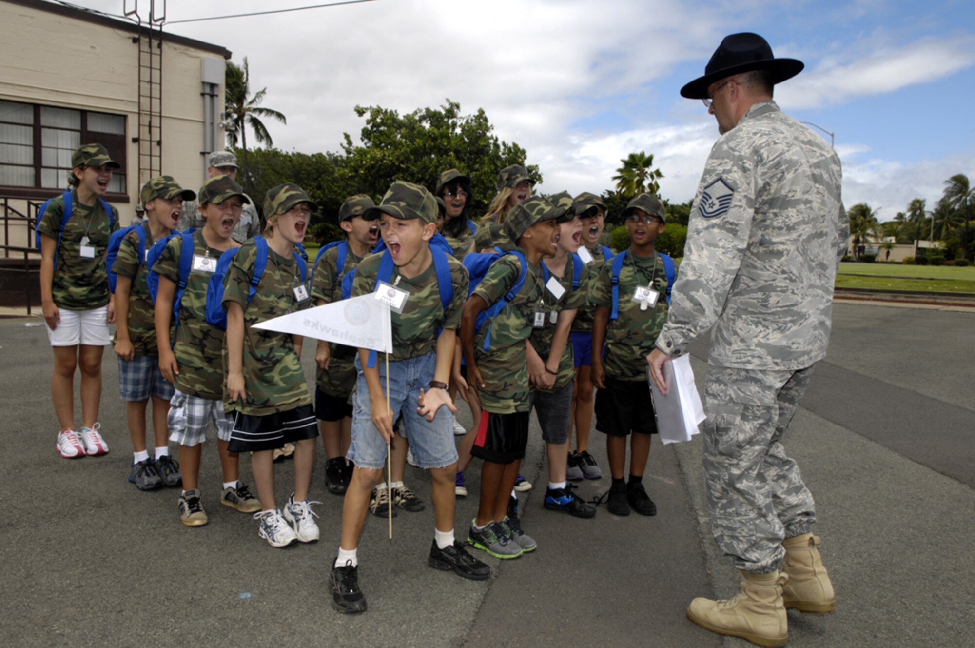 Master Sgt. Jody Parker gets children "motivated" during Operation Hele-On, a mock deployment for military families at Joint Base Pearl Harbor-Hickam, Hawaii, Aug 19. 155 children participated in the annual event, which included getting mobility bags and "gear" issued, getting bussed to the flight line, and a tour of the KC-135. This experience was geared to help children understand what their parents go through during a real military deployment. (U.S. Air Force photo/David D. Underwood, Jr.)
