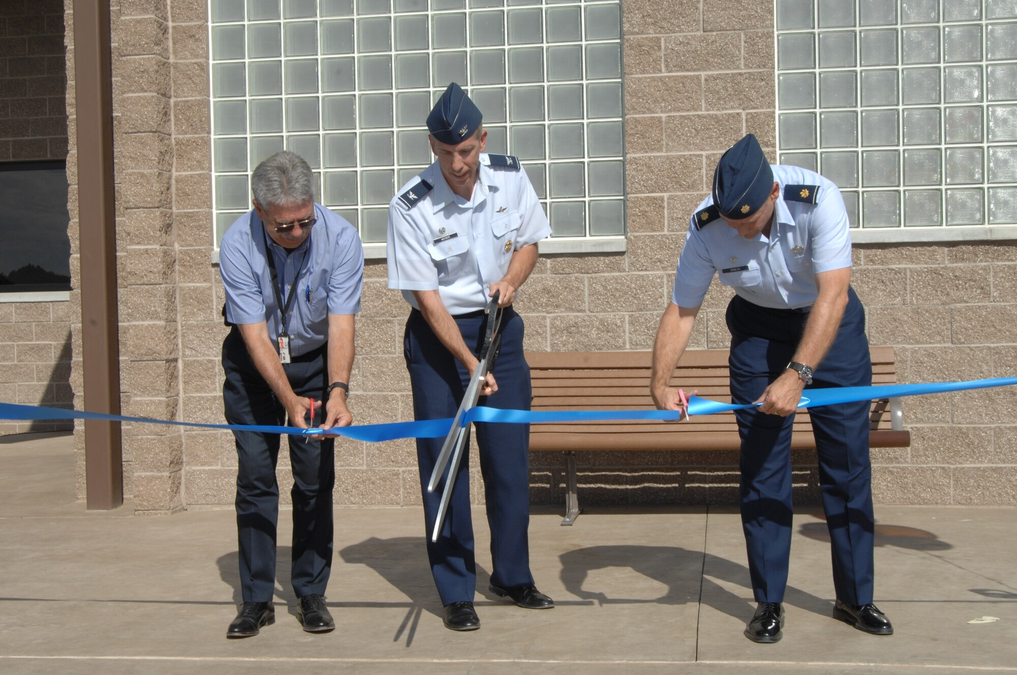 MOUNTAIN HOME AIR FORCE BASE, Idaho – Col. Scott Moser, 366th Mission Support Group commander, Maj. Ken Dewlen, 366th Force Support Squadron commander and Les Mitchell, 366th Civil Engineering Squadron project manager, cut the ribbon to officially open the newly renovated Gunfighter Service Center here Aug. 24. The project took more than 2 years to complete with a cost of $6.7 million. Renovating versus rebuilding the facility saved more than $13 million. (U.S. Air Force photo by Senior Airman Benjamin Sutton)       