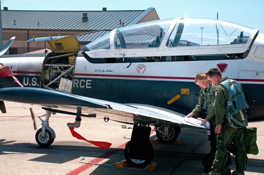 LAUGHLIN AIR FORCE BASE, Texas — Capt. Nicole Jansen, 47th Operations Support Squadron, prepares for a T-6 Texan II orientation flight with Ross Parton, Air Force artist. The 47th Flying Training Wing hosted four artists from the program Aug. 14 through Aug. 19. The artists toured Laughlin and received orientation flights in the T-6 and T-1 Jayhawk to help inspire them to create artwork about the mission here. (U.S. Air Force photo/Senior Airman Scott Saldukas)