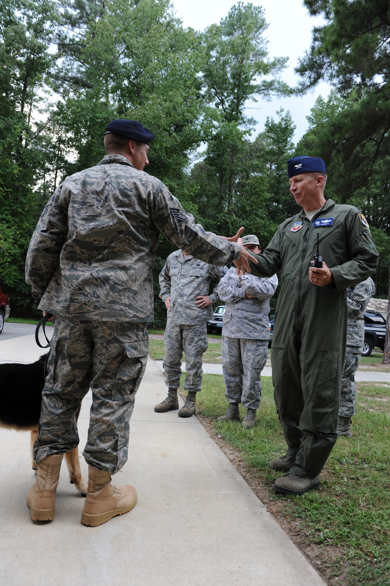 SEYMOUR JOHNSON AIR FORCE BASE, N.C.—Col. Patrick Doherty shakes the hand of Staff Sgt. Benjamin Seekell here Aug. 19, 2011 as he greets both Seekell and his military working dog Charlie.  Seekell and Charlie were injured by a landmine outside Bagram Airfield, Afghanistan in early May.  Seekell is a military working dog handler from the 4th Security Forces Squadron and Doherty is the 4th Fighter Wing commander. (U.S. Air Force photo by 2nd Lt. Keavy Rake/Released)