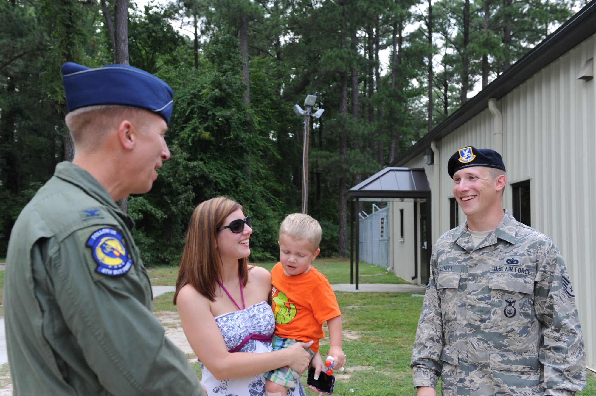 SEYMOUR JOHNSON AIR FORCE BASE, N.C.—Staff Sgt. Benjamin Seekell, 4th Security Forces Squadron military working dog handler, shares a laugh with his wife  and son here Aug. 19,2011 as they are greeted by Col. Patrick Doherty, 4th Fighter Wing commander.  Seekell lost his left foot in early May when he stepped on a landmine outside Bagram Airfield, Afghanistan. Seekell hails from Charlestown, R.I.  (U.S. Air Force photo by 2nd Lt. Keavy Rake/Released)