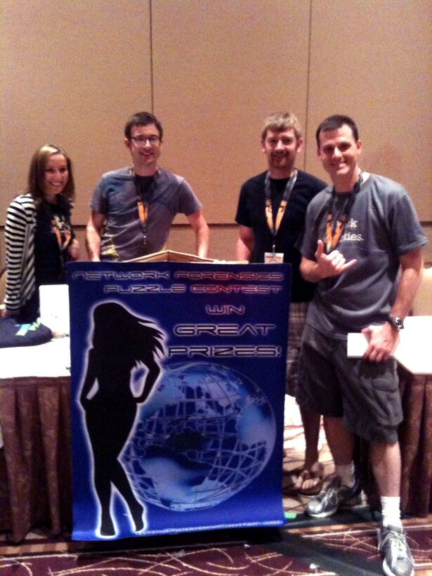Special Agent Kyle McCracken, right, accepts the second place award in the network forensics contest on behalf of the OSI cyber team at the DEF CON 19 conference. There were several contests during the conference, including lock-picking, art, slogan, scavenger hunt, capture the flag and network forensics. (U.S. Air Force photo courtesy of SA Kyle McCracken.)