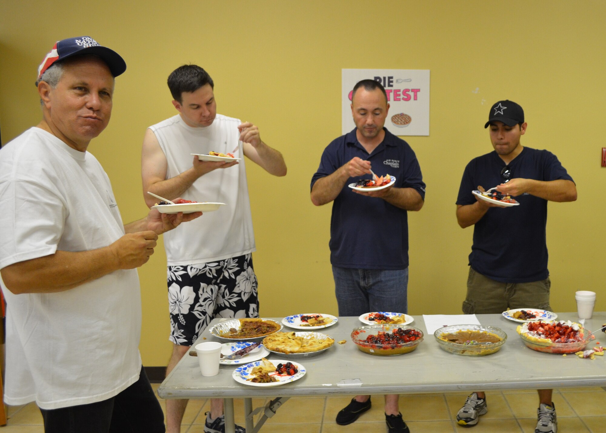 LAUGHLIN AIR FORCE BASE, Texas -- Father Tom Edelen (far left), Laughlin priest, takes a bite of pie during a pie contest held during the Fair by the Chapel here Aug. 21. Father Edelen volunteered to move to Laughlin when he saw a need for a priest. The Laughlin Chapel has been without a full-time priest for more than 11 months. (Contributed photo)