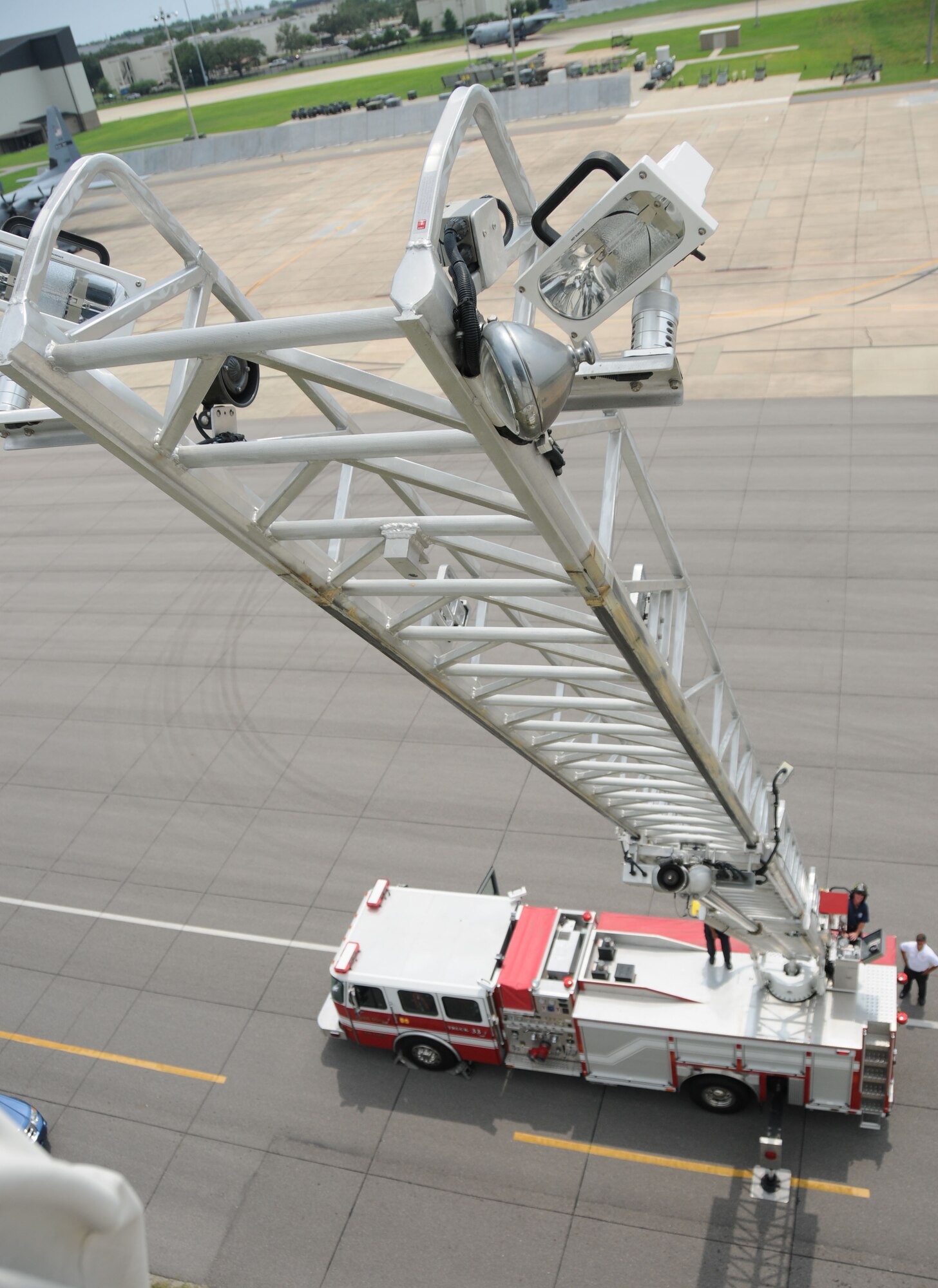 Keesler firefighter Raymond Bell extends the fire truck ladder and carefully places it against the air traffic control tower as a means of escape as part of fire rescue training Aug. 17.  (U.S. Air Force photo by Kemberly Groue)