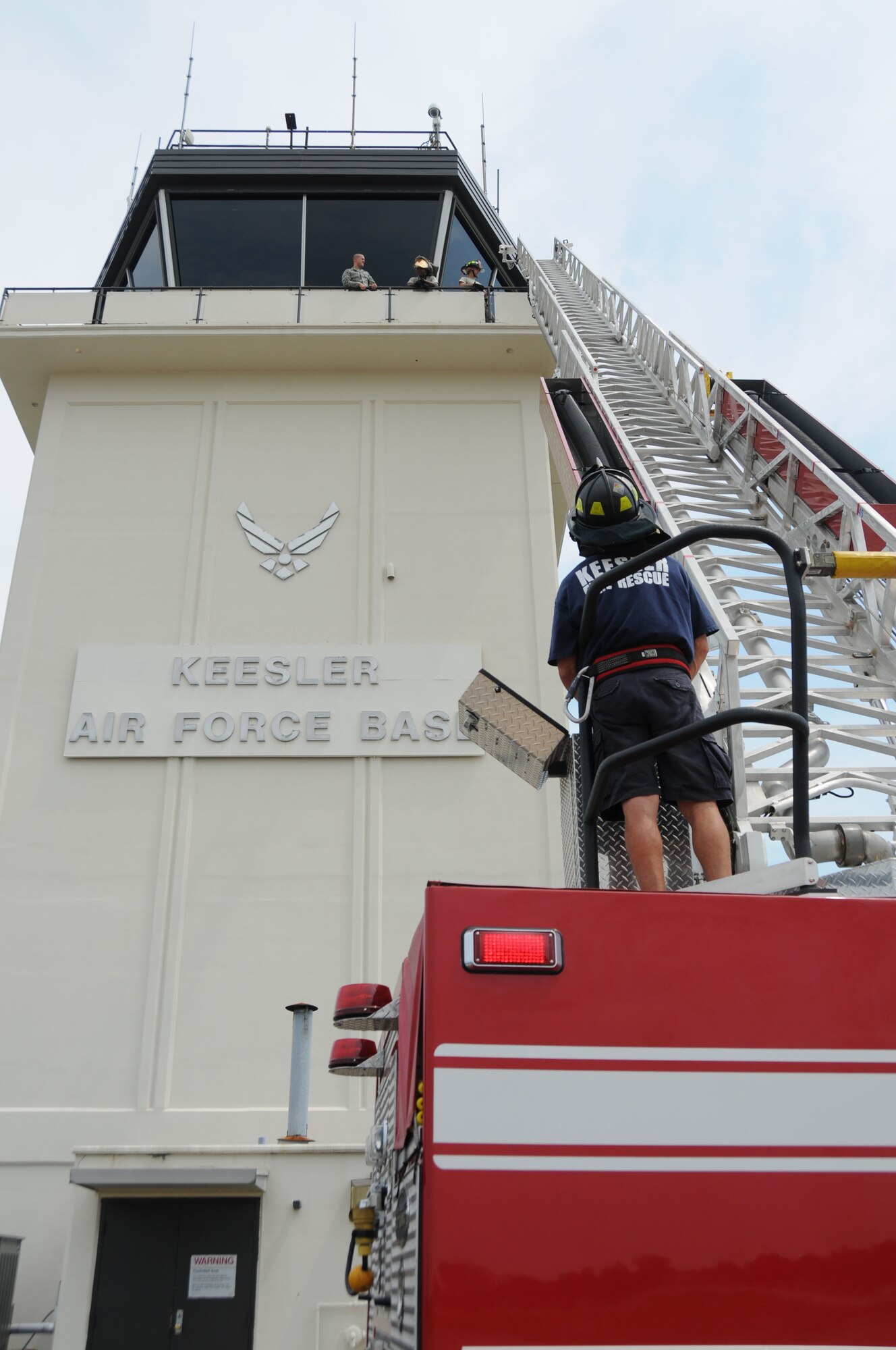 Keesler firefighter Raymond Bell extends the fire truck ladder and carefully places it against the air traffic control tower as a means of escape as part of fire rescue training Aug. 17.  (U.S. Air Force photo by Kemberly Groue)