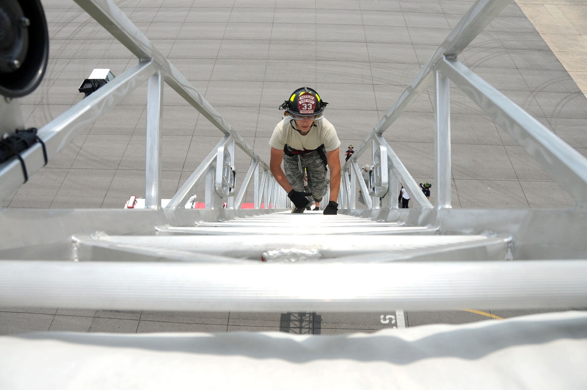 Airman 1st Class Matthew Whelan, a Keesler firefighter, climbs the extended fire truck
ladder toward the air traffic control tower as part of fire rescue training Aug. 17.  (U.S. Air Force photo by Kemberly Groue)
