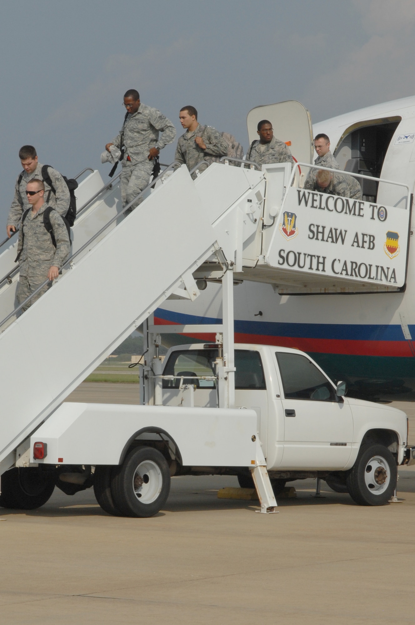 Air Force personnel from the 55th Fighter Squadron and the 20th Aircraft Maintenance Squadron disembark from a Boeing-737 from Nellis Air Force Base, Nev., after the completion of Nellis Green Flag West 11-9 on the flight line, Shaw AFB, S.C., Aug. 19, 2011. Nine Airmen from the 20th LRS small air terminal worked to load up the C-5 Galaxy from Westover, Mass. with 68,000 pounds of aerospace ground equipment to support multiple F-16 Fighting Falcon flying missions around the globe.  In the middle of that task, the same maintainers off-loaded the Boeing-737 personnel, their gear and luggage. The Boeing-737 was filled with Nellis Green Flag West 11-9 returning personnel from the 55th Fighter Squadron and the 20th Aircraft Maintenance Squadron. (U.S. Air Force photo by 1st Lt. Ann Blodzinski) (Released)