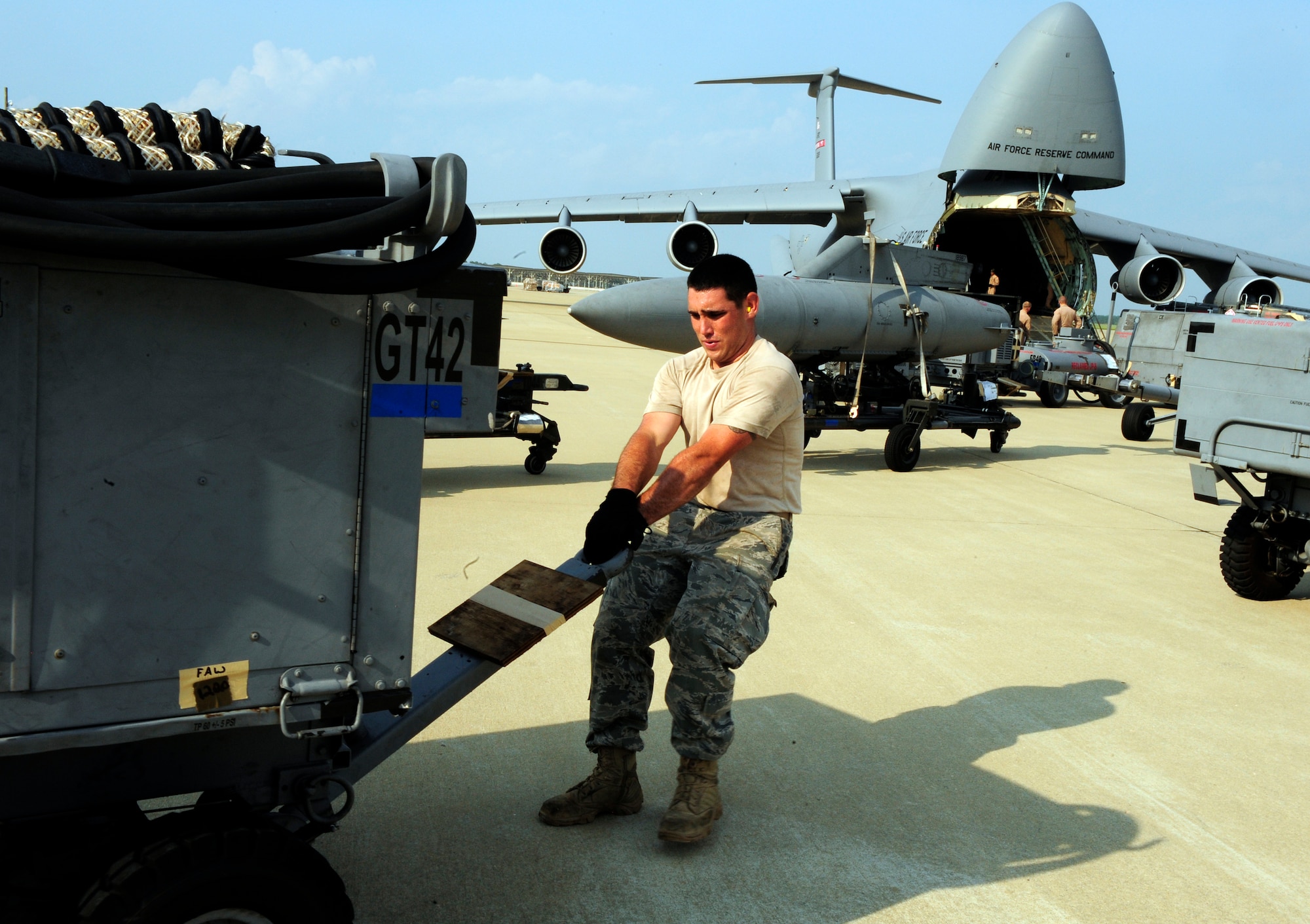 U.S. Air Force Senior Airman Steven Short, 20th Logistics Readiness Squadron cargo development facility vehicle maintainer, pulls cargo to the awaiting C-5 Galaxy on the flight line, Shaw Air Force Base, S.C., Aug. 19, 2011. Nine Airmen from the 20th LRS small air terminal worked to load up the C-5 Galaxy from Westover, Mass. with 68,000 pounds of aerospace ground equipment to support multiple F-16 Fighting Falcon flying missions around the globe.  In the middle of that task, the same maintainers off-loaded the Boeing-737 personnel, their gear and luggage. The Boeing-737 was filled with Nellis Green Flag West 11-9 returning personnel from the 55th Fighter Squadron and the 20th Aircraft Maintenance Squadron. (U.S. Air Force photo by Tech. Sgt. Louis Rivers) (Released)