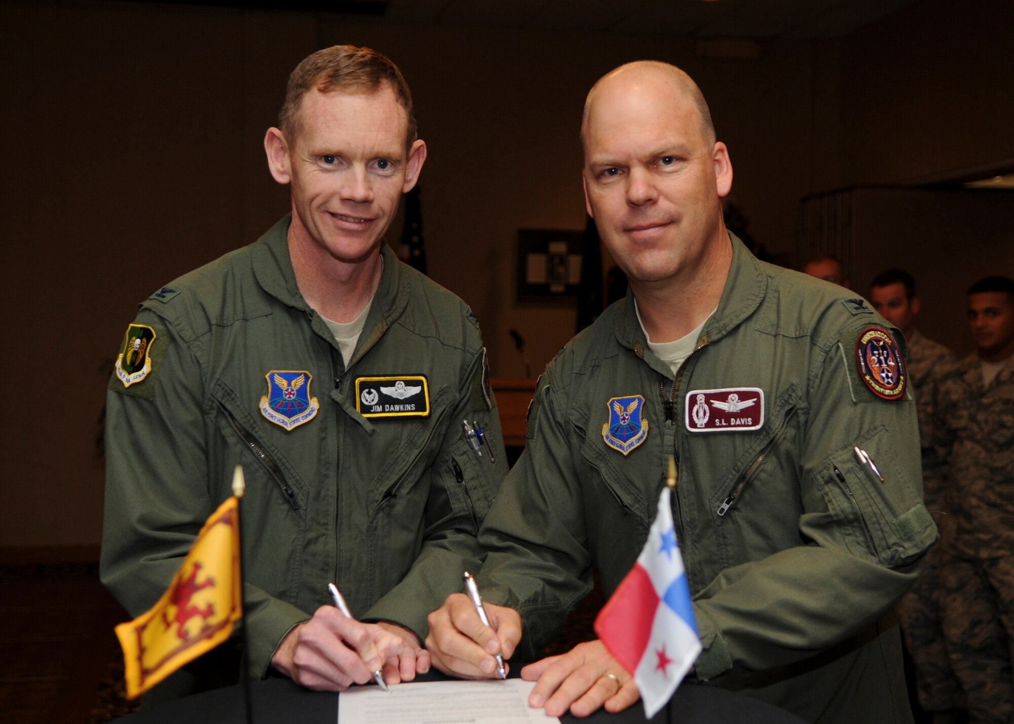 MINOT AIR FORCE BASE, N.D. -- Col. James Dawkins, 5th Bomb Wing commander, and Col. Stephen Davis, 91st Missile Wing commander, sign the Minot Air Force Base Diversity Day Proclamation at the Jimmy Doolittle Center Aug. 19. The signing of the proclamation started off the event. The event ran for approximately five hours and included a variety of multi-cultural booths, cooking, dancing, singing, and poetry. (U.S. Air Force photo/Senior Airman Ashley N. Avecilla) (RELEASED)