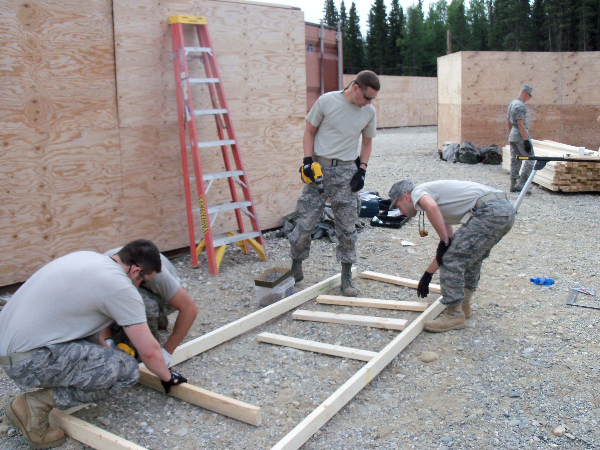 148th Fighter Wing Civil Engineering Squadron members Staff Sgt. Tom Jackson, Staff Sgt. Michael Wing, Senior Airman Brent Micken, and Airman 1st Class Jacob Olson construct part of asimulated village at Fort Greely, Delta Junction, Alaska July 23, 2011. The Army will use the village to train tactical movements and building clearing procedures. 
