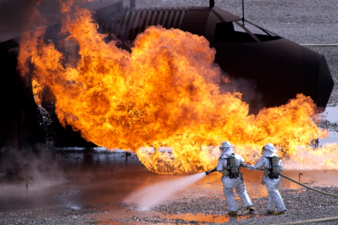 GRISSOM AIR RESERVE BASE, Ind. -- Army Guardsmen from Camp Atterbury Indiana, move into position to attack a simulated aircraft fire during training held here. The members of the Indiana National Guard came to the base to learn how to practice responding to an aircraft incident. (U.S. Air Force photo/Tech. Sgt. Douglas Hays)