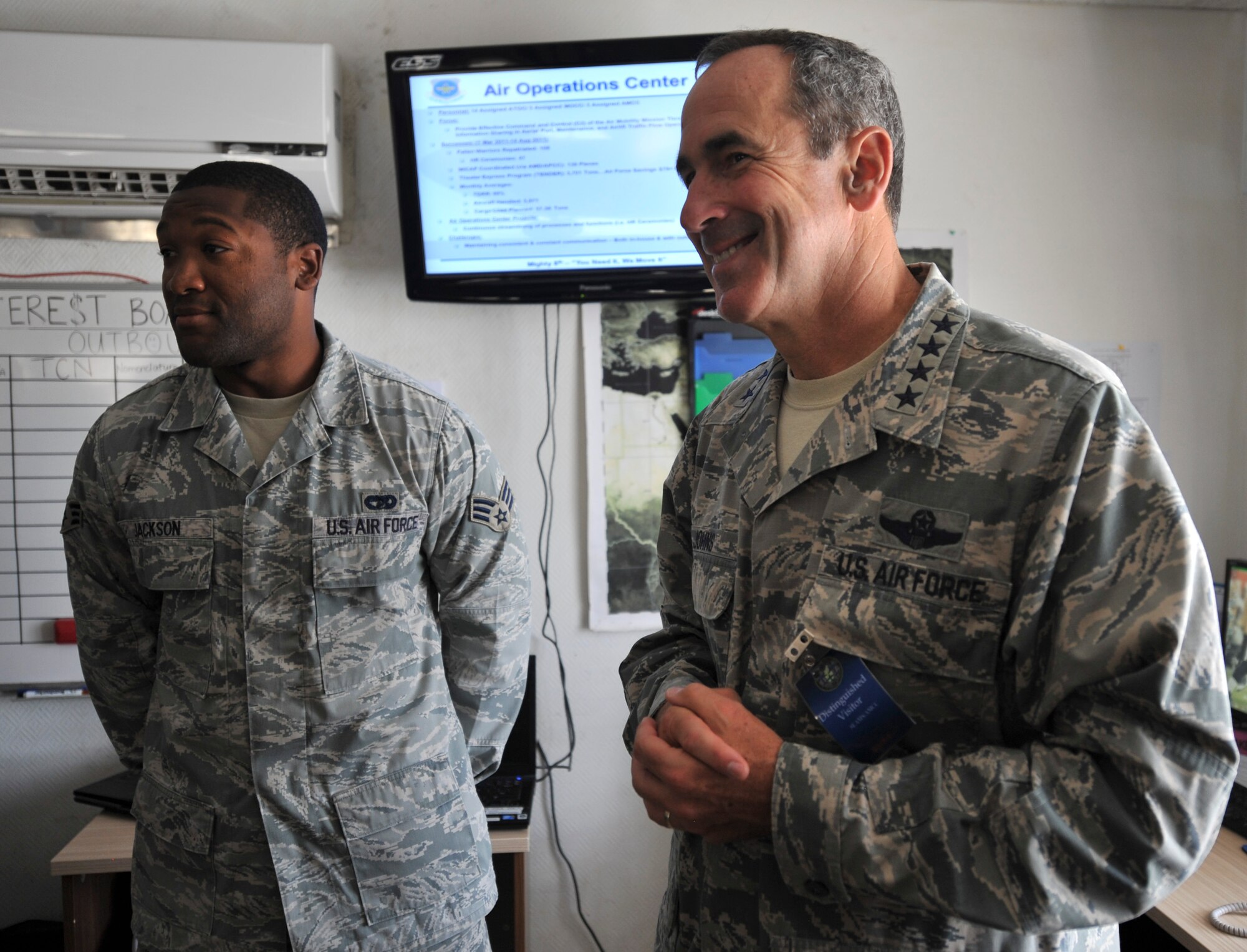 Gen. Raymond E. Johns Jr., Air Mobility Command commander, speaks with Senior Airman Adrian Jackson, 8th Expeditionary Air Mobility Squadron air terminal operations center information controller, during a visit Aug. 17 to an undisclosed location in Southwest Asia.  Jackson, a native of Ocean Springs, Miss., is deployed from the 724th Air Mobility Squadron at Aviano Air Base, Italy. (U.S. Air Force photo/Senior Airman Paul Labbe)