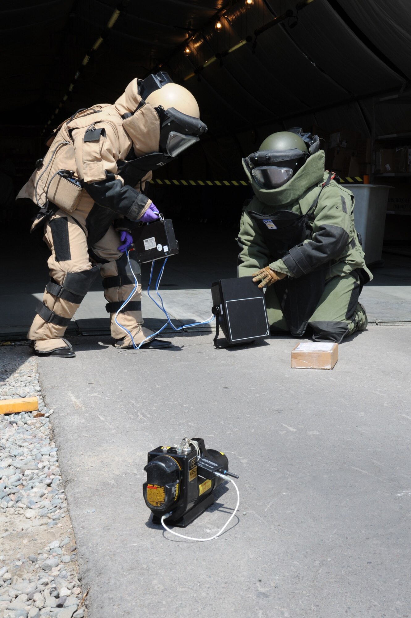 Tech. Sgt. Mack Saterfield (green bomb suit) and a Kyrgyz Republic soldier X-ray a suspicious package during a bilateral information exchange scenario at the Transit Center at Manas, Kyrgyzstan, Aug. 19. The servicemembers are both explosive ordnance disposal technicians. Saterfield is deployed to the 376th Expeditionary Civil Engineer Squadron from Mountain Home Air Force Base, Idaho. (U.S. Air Force photo/Tech. Sgt. Hank Hoegen)