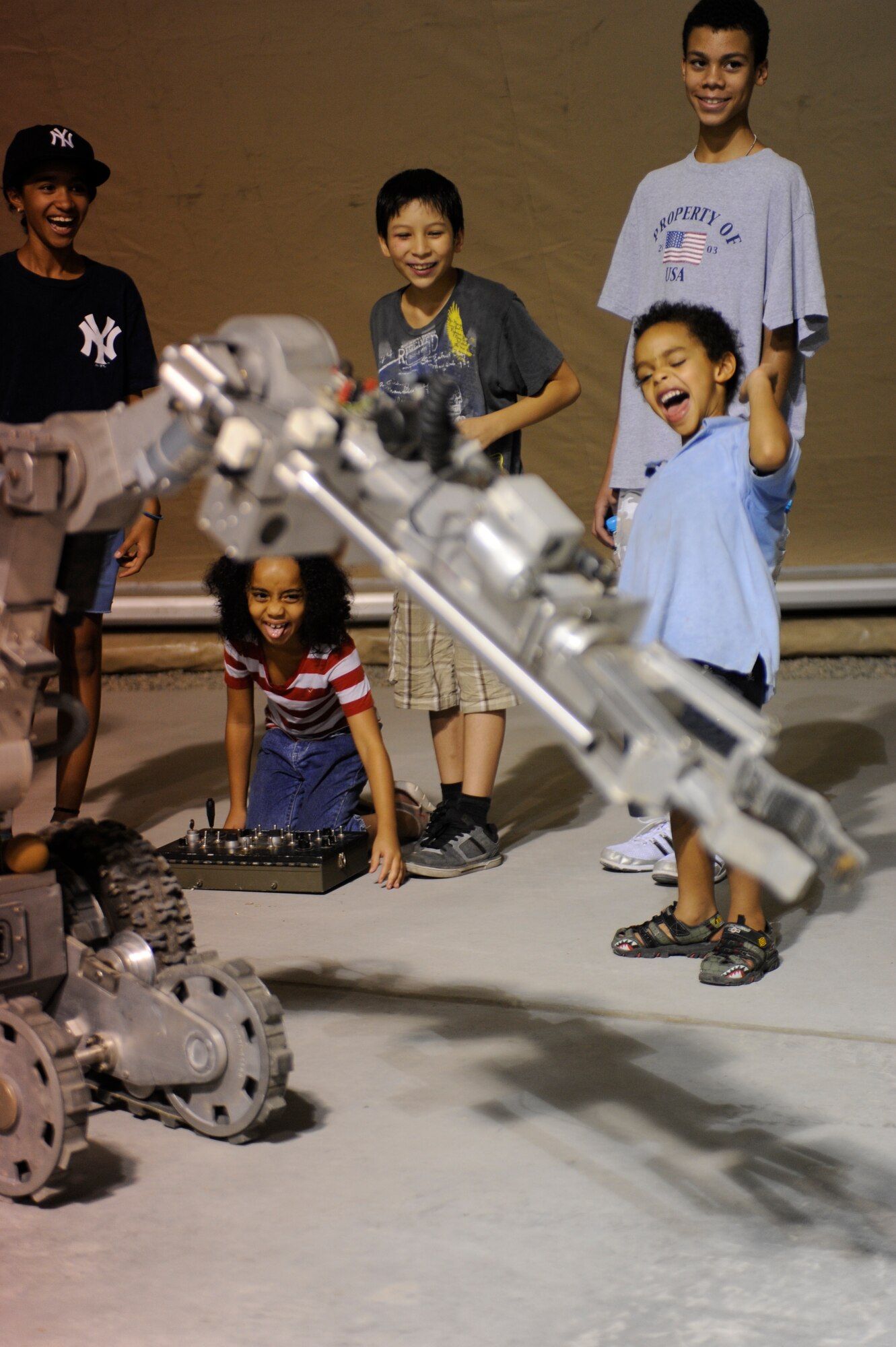 Esabella Pacheco, 7, drops a can from the arm of an F-6A explosive ordnance disposal robot as other children watch during a U.S. Embassy Family Day tour of the Transit Center at Manas, Kyrgyzstan, Aug. 20. (U.S. Air Force photo/Tech. Sgt. Tammie Moore)