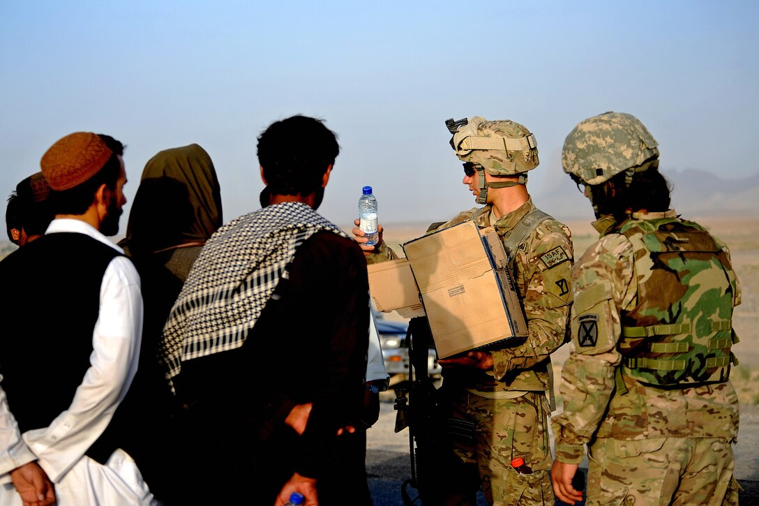 U.S. Army Spc. Christopher Perez hands out water during a bridge quality assurance inspection along Highway 1 in Zabul province, Afghanistan, Aug. 22, 2011. Perez is assigned to the Provincial Reconstruction Team Zabul's security force and is deployed from the Massachusetts National Guard.