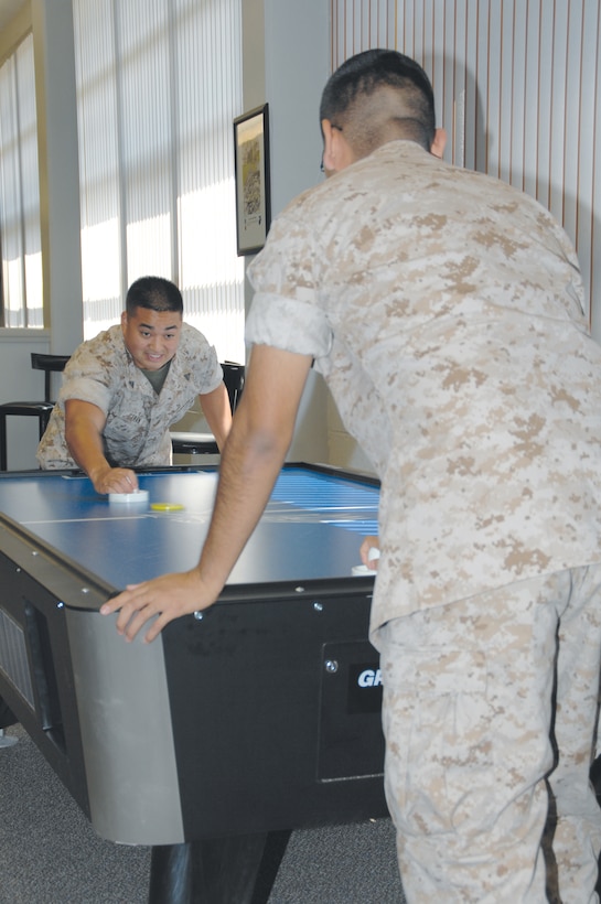 Cpl. Michael H. Tran, supply clerk, Marine Corps Systems Command, plays air hockey with another Marine at the Single Marine Recreation Center, Aug. 25. Air hockey is one of several games available for single Marines and sailors to play.