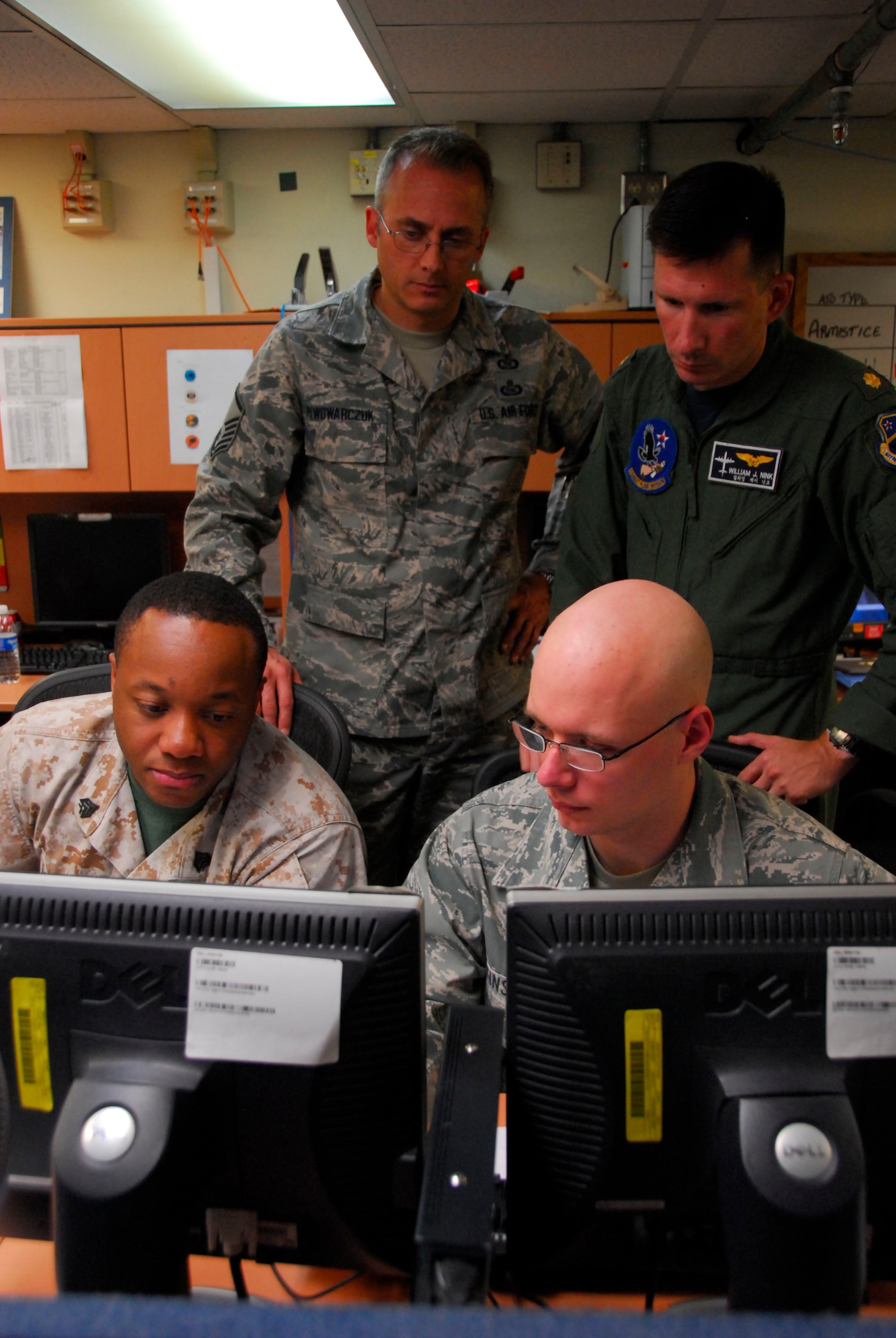 Master Sgt. Bohdan Pywowarczuk, Lt. Cdr. William Nink, (top) Sgt. Christopher Generette and SrA Sean Tinsley perform a quality check on an Air Tasking Order prior to publication, Aug. 24. during Ulchi Freedom Guardian 2011 exercise on Osan Air Base, Rupublic of Korea. (U.S. Air Force photo/Master Sgt. Kimberly Spinner)