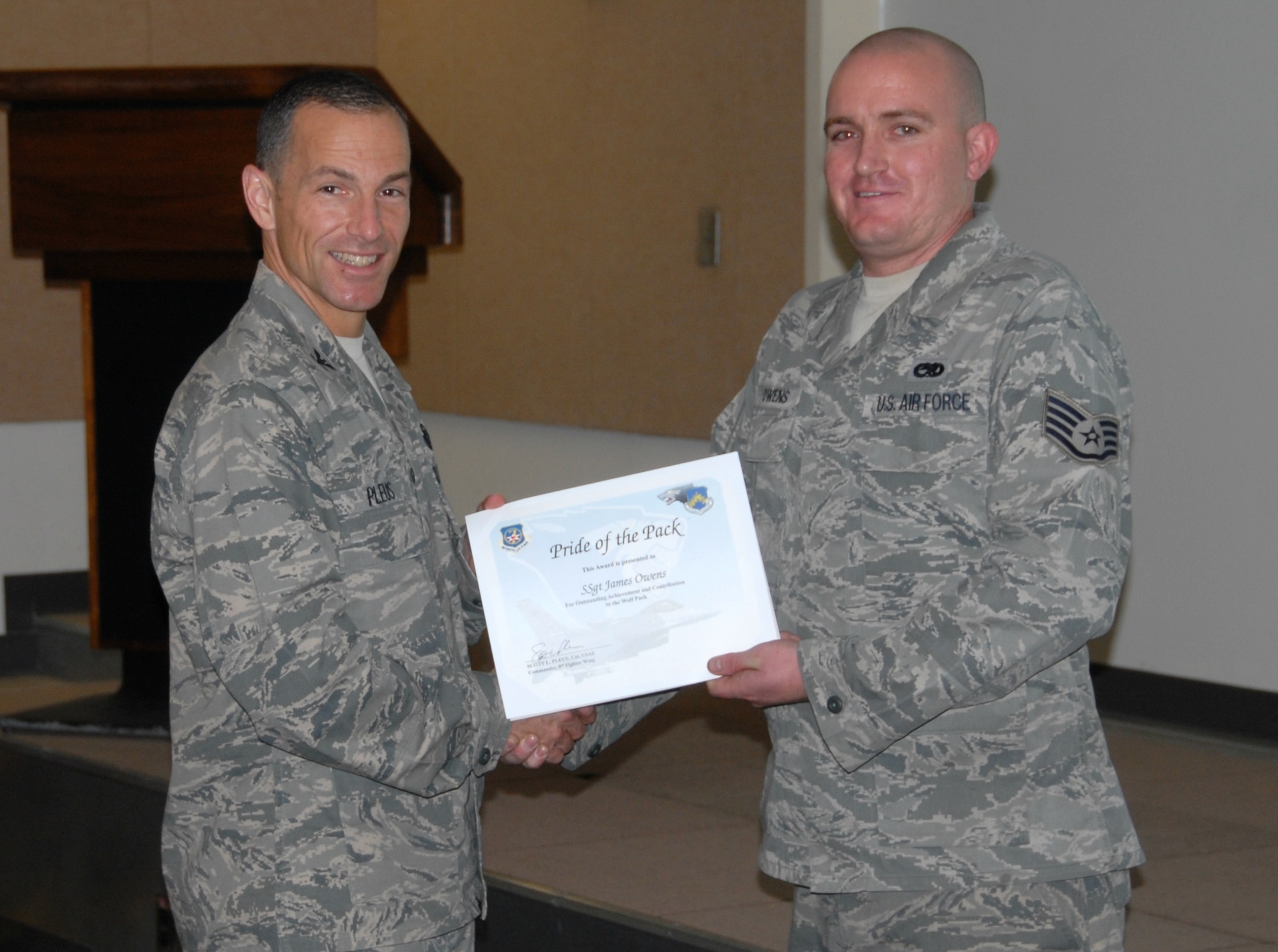 KUNSAN AIR BASE, Republic of Korea -- Col. Scott Pleus, 8th Fighter Wing commander, presents Staff Sgt. James Owens, 8th Aircraft Maintenance Squadron crew chief, with the 'Pride of the Pack' award here Aug. 25. (U.S. Air Force photo/Capt. Omar Villarreal)