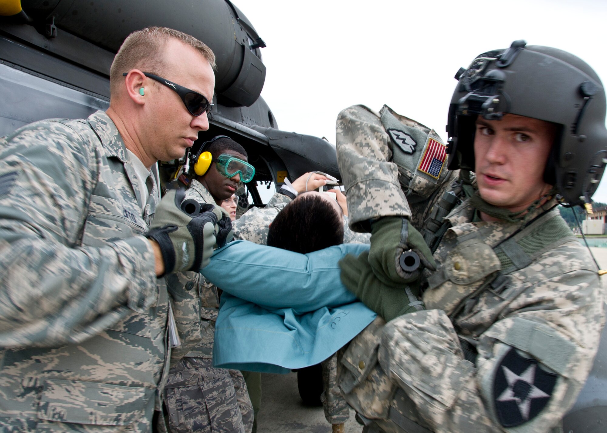 (Left) Staff Sgt. Benjamin Lifto, 51st Medical Group independent duty medical technician, and Staff Sgt. Justin Cauthen, Charlie Company 3rd General Support Aviation Battalion, 2nd Aviation Regiment, 2nd Combat Aviation Brigade, 2nd Infantry Division flight medic, unload a patient during Dragon Lift, Aug. 24, 2011. During the exercise Airmen were evaluated on their ability to retrieve patients from the staging area and safely and swiftly transport them to the patient staging area. (U.S. Air Force photo/Senior Airman Adam Grant)