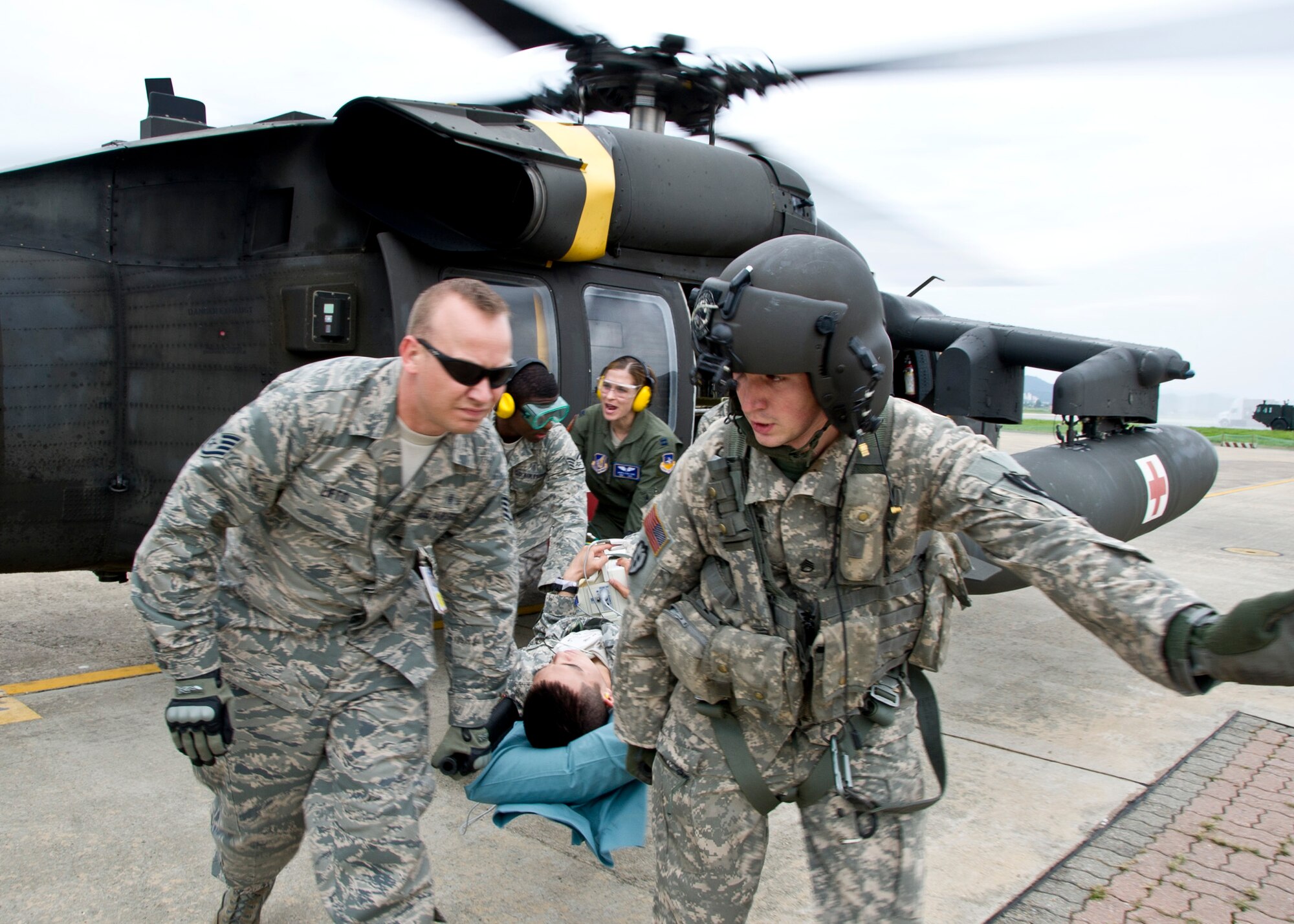 (Left) Staff Sgt. Benjamin Lifto, 51st Medical Group independent duty medical technician, and Staff Sgt. Justin Cauthen, Charlie Company 3rd General Support Aviation Battalion, 2nd Aviation Regiment, 2nd Combat Aviation Brigade, 2nd Infantry Division flight medic, unload a patient during Dragon Lift, Aug. 24, 2011. During the exercise the participants were evaluated on their ability to retrieve patients from the staging area and safely and swiftly transport them to the patient staging area. (U.S. Air Force photo/Senior Airman Adam Grant)