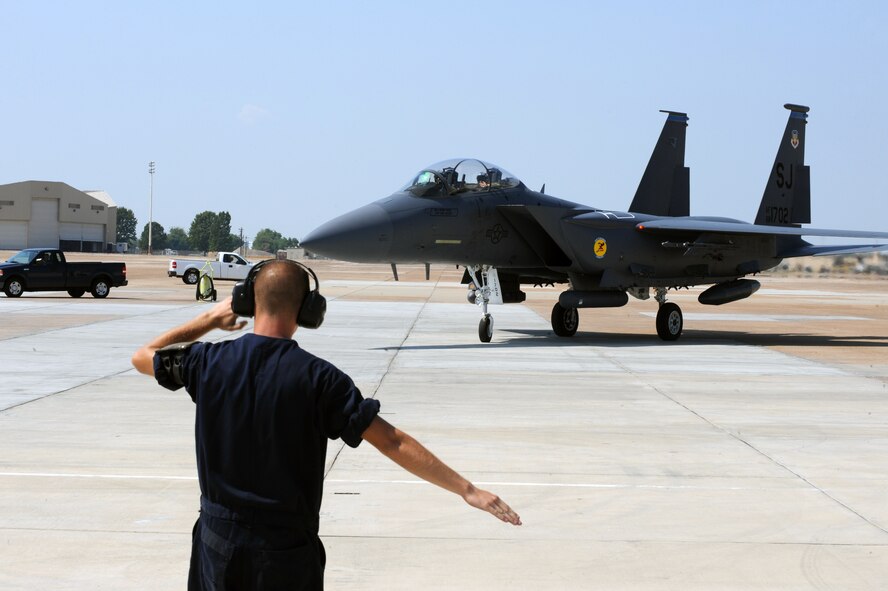 An Airman from Seymour Johnson Air Force Base, N.C., directs an F-15E Strike Eagle down the ramp on Barksdale Air Force Base, La., Aug. 25. F-15Es, KC-135R Stratotankers and their ground crew evacuated Seymour Johnson AFB due to a hurricane projected to hit the East coast over the next few days. The Airmen flew in on KC-135Rs to help maintain their aircraft. (U.S. Air Force photo/Airman 1st Class Micaiah Anthony)(RELEASED)
