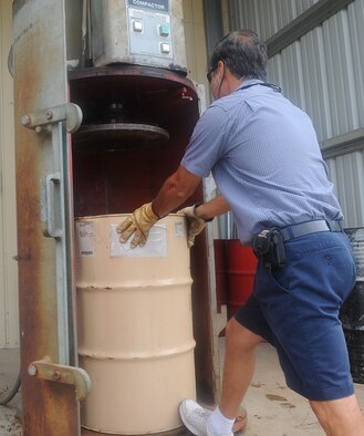 Alfredo Garza, 2nd Civil Engineer Squadron recycling manager, pushes a steel barrel into a compactor at the recycling center on Barksdale Air Force Base, La., Aug. 25. The barrels are compacted to save space in the dumpsters for other recyclables. (U.S. Air Force photo/Senior Airman Kristin High)(RELEASED)