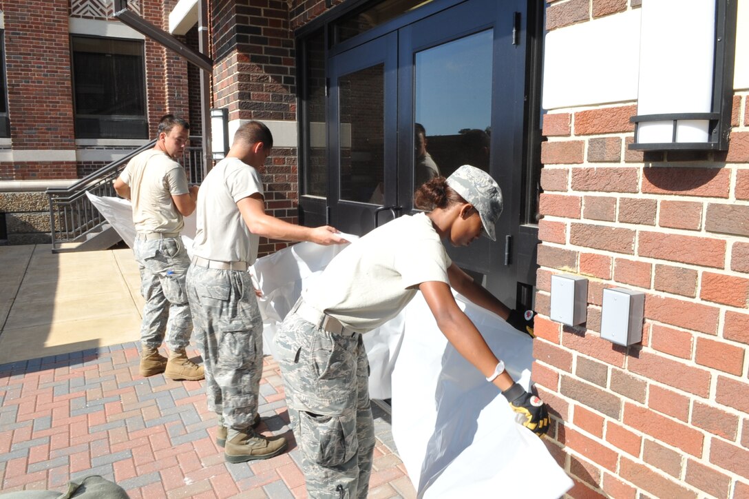 Senior Airman Sally Kabugwa, 633rd Civil Engineer Squadron structures technician, Senior Airman Joshua Fogle and Airman 1st Class Justin Murphy, 633rd CES power production technicians, prepare for Hurricane Irene by sandbagging the Air Combat Command fitness center doorways at Langley Air Force Base, Va., Aug. 25, 2011. Langley AFB is preparing for the hurricane, which is expected to make landfall in the area on early Sunday morning. (U.S. Air Force photo by Staff Sgt. Logan Tuttle/released)