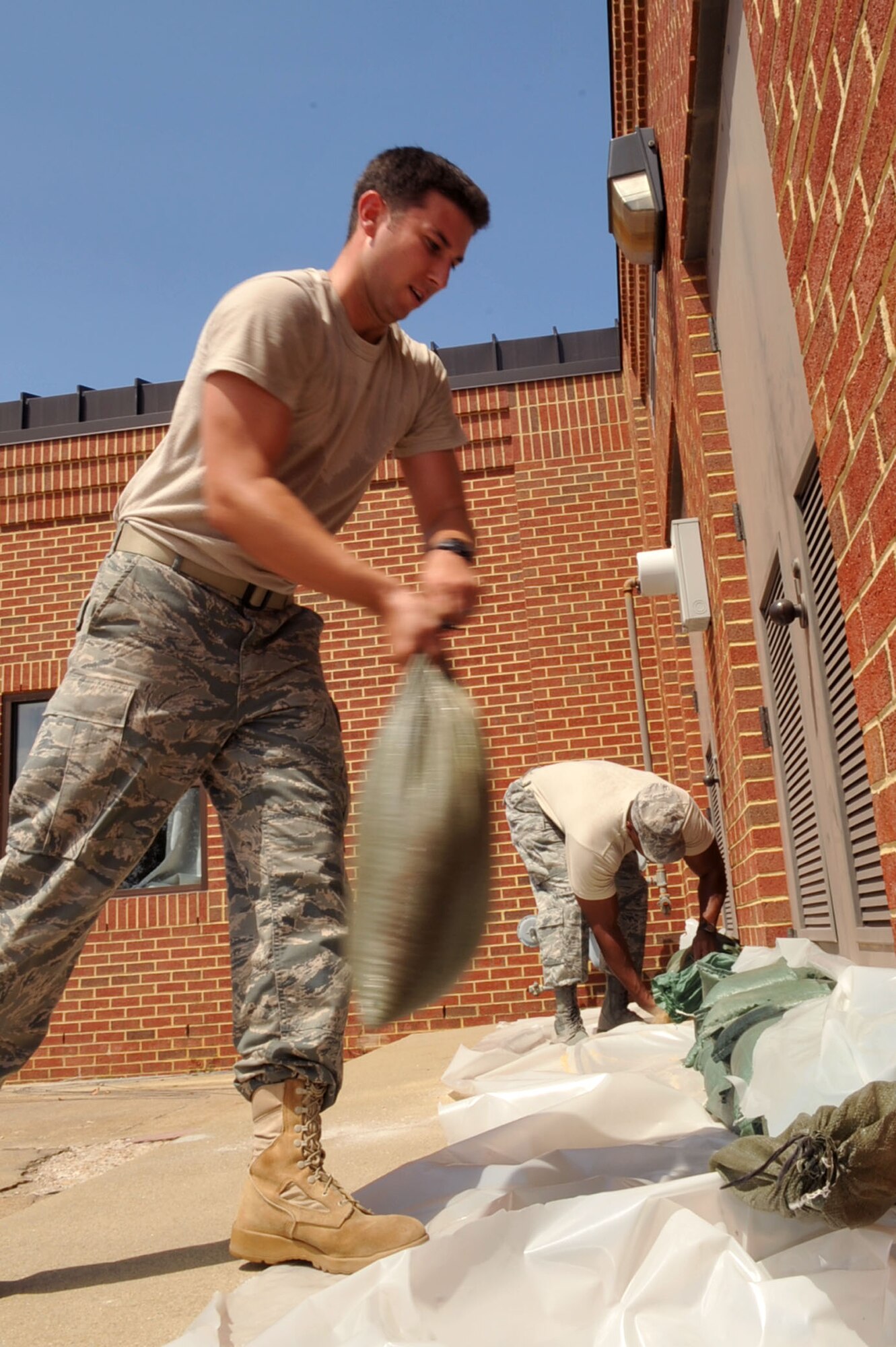 1st Lt. Phill Bergeron, 15th Intel Squadron chief of standards and evaluation, adds a row of sandbags to a doorway at the Air Force Targeting Center at Langley Air Force Base, Va., Aug. 25, 2011. Langley AFB is preparing for Hurricane Irene, which is expected to make landfall in the area on early Sunday morning. (U.S. Air Force photo by Staff Sgt. Logan Tuttle/released)