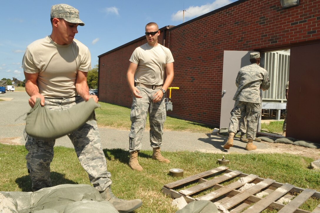 Airmen 1st Class Micheal Leaonard, 633rd Communications Squadron core systems technician, and Alec Krabbe, 633rd CS client system technician, sandbag the doorways at the base telephone office to prevent flooding at Langley Air Force Base, Va., Aug. 25, 2011. Langley AFB is preparing for Hurricane Irene, which is expected to make landfall in the area on early Sunday morning. (U.S. Air Force photo by Staff Sgt. Logan Tuttle/released)