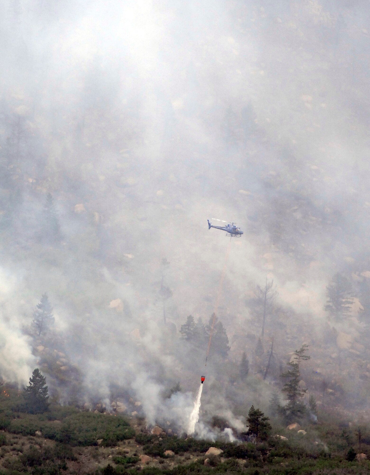 A helicopter dumps water on a section of the Beaver Creek fire Aug. 19, 2011. The fire burned approximately 100 acres north of the Air Force Academy before it was extinguished. Firefighters from the Tri-Lakes and Air Force Academy fire departments helped fight the blaze. (U.S. Air Force photo/Mike Kaplan)