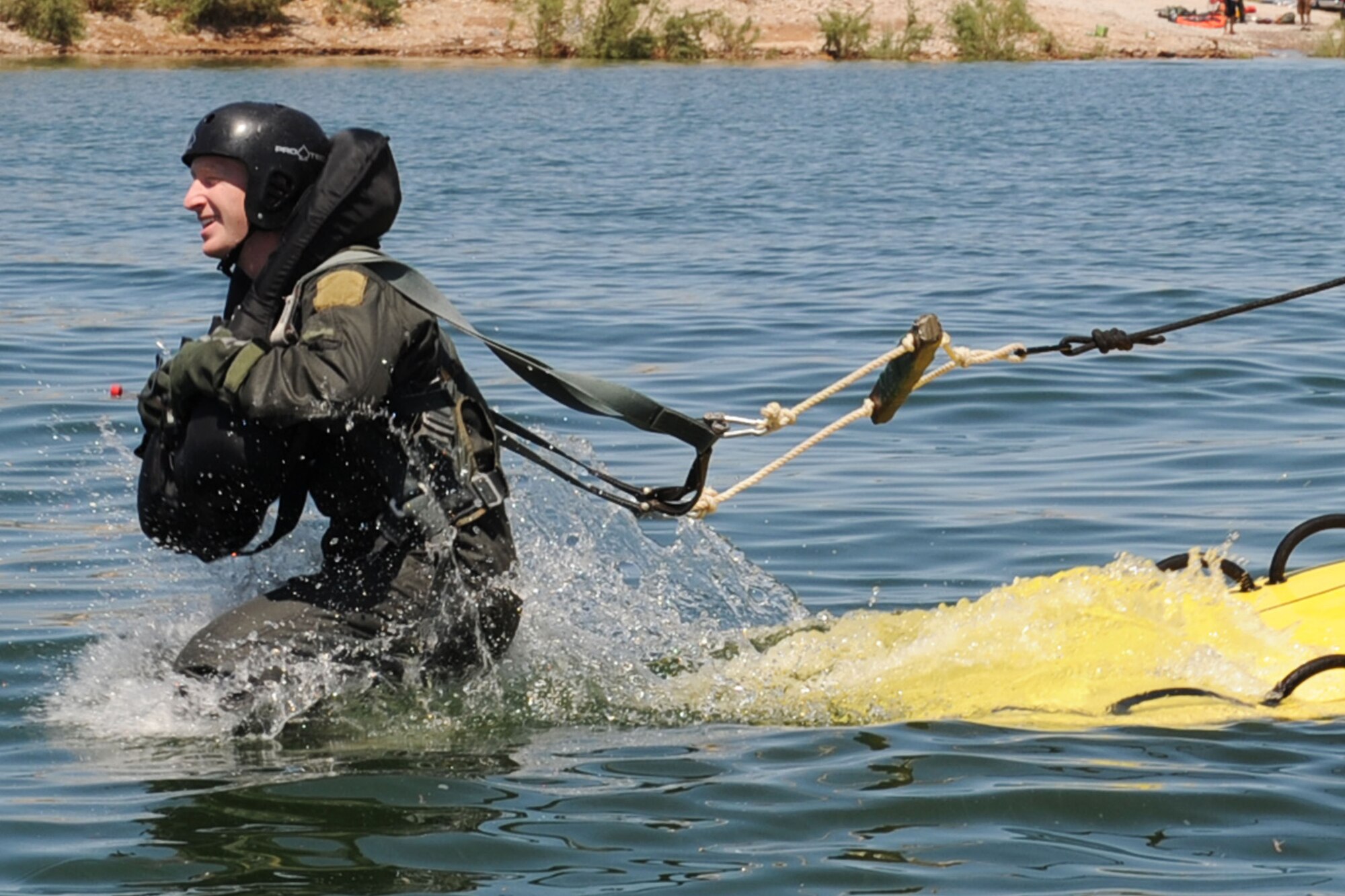 U.S. Air Force Capt. Justin Elliott, 422nd Test and Evaluation Squadron, F-15E Strike Eagle Division pilot, jumps into the lake for a simulation parachute drag during water survival training with 57th Operation Support Squadron Survival, Evasion, Resistance and Escape Specialists at Lake Mead, Nev. Aug. 17, 2011.  SERE specialists train high risk aircrew personnel to survive, evade, and return should they eject, bailout, or otherwise become isolated during combat, anywhere in the world. (U.S. Air Force photo by Staff Sgt. Taylor Worley/Released)