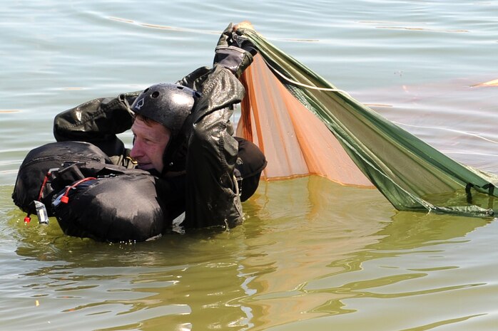 U.S. Air Force Capt. Justin Elliot, 422nd Test and Evaluation Squadron, F-15E Strike Division pilot, slides underneath a parachute during water survival training at Lake Mead, Nev. Aug. 17, 2011,  SERE specialists train high risk aircrew personnel to survive, evade, and return should they eject, bailout, or otherwise become isolated during combat, anywhere in the world. (U.S. Air Force photo by Staff Sgt. Taylor Worley/Released)