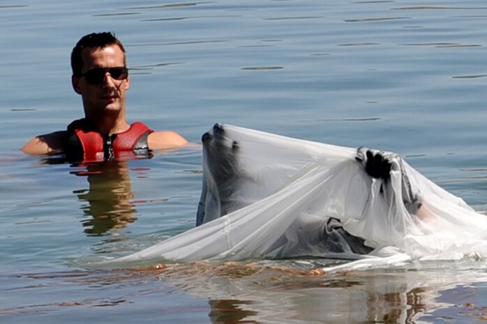 U.S. Air Force Staff Sgt. Dave Janossy, 57th Operation Support Squadron Survival Evasion Resistance and Escape Specialist, observes U.S. Air Force Maj. Jeff Cannon, 57th Weapons Support Squadron, F-15E Strike Eagle pilot, as he finds his way out from under a parachute during water survival training at Lake Mead, Nev. Aug. 17, 2011.  SERE specialists train high risk aircrew personnel to survive, evade, and return should they eject, bailout, or otherwise become isolated during combat, anywhere in the world. (U.S. Air Force photo by Staff Sgt. Taylor Worley/Released)