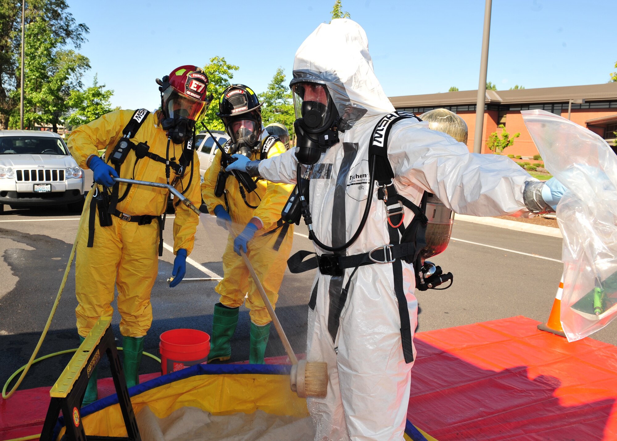 Senior Airman Jeffrey Gomez, 92nd Aeromedical Dental Squadron, goes through a Mobile Decon/Rehab unit setup by the 92nd Civil Engineer Squadron fire department during the exercise Aug. 17. The purpose of the exercise was to evaluate the ability to respond to a public health emergency by exercising the mass prophylaxis, testing the ability to stand up the point of distribution and employing medical counter measures. (U.S. Air Force photo/Staff Sgt. Michael Means)
