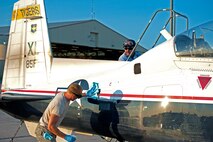 LAUGHLIN AIR FORCE BASE, Texas – 2nd Lt. Ricky Gelles, 47th Operation Support Squadron, and Rogelio Rodriguez, T-6 Texan II crew chief, wipe down a T-6 as morning operations begin here Aug. 25. (U.S. Air Force photo/Senior Airman Scott Saldukas) 