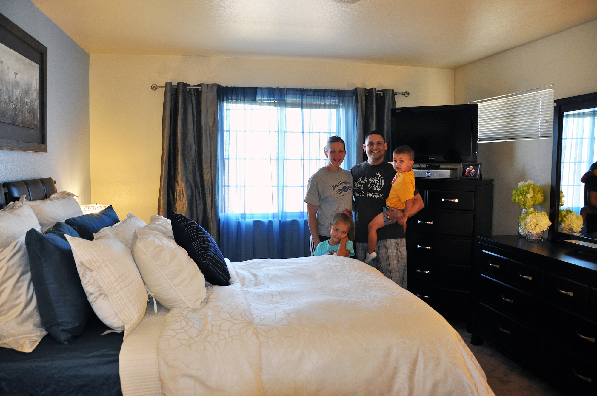 Staff Sgt. Rachel Hawkins and Staff Sgt. Ethan Hawkins stand with their children, Jada and Caleb, in their newly renovated bedroom courtesy of the 60th Force Support Squadron Full Access Marketing and Balfour Beatty Communities. (U.S. Air Force photo/Airman Madelyn Ottem)