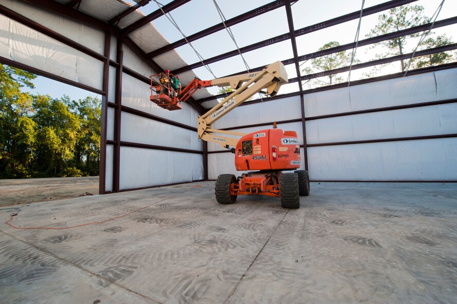 Members of the 823rd RED HORSE Squadron based out of Hurlburt Field Air Force Base, Fla., place insulation along the roof of a warehouse being built on Moody Air Force Base, Ga., Aug. 25, 2011. The civil engineers go on temporary duty assignments around their local area to prepare themselves for real world rapid deployments.  (U.S. Air Force photo by Staff Sgt. Joshua J. Garcia/Released)