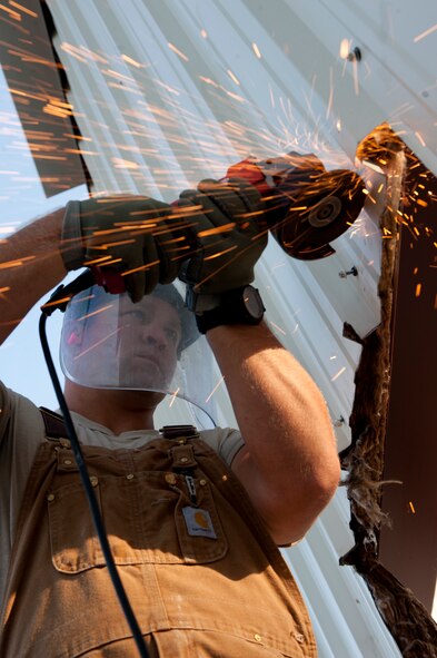 U.S. Air Force Staff Sgt. Jeff Updyke, 823rd RED HORSE Squadron from Hurlburt Field, Fla., cuts siding with an electric handsaw to make a doorway during a warehouse build on Moody Air Force Base, Ga., Aug. 25, 2011. The warehouse is scheduled to be completed by Oct. 1. (U.S. Air Force photo by Staff Sgt. Joshua J. Garcia/Released)