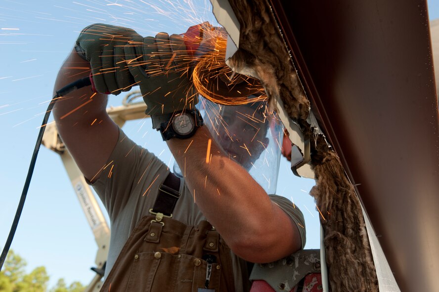 U.S. Air Force Staff Sgt. Jeff Updyke, 823rd RED HORSE Squadron from Hurlburt Field, Fla., cuts siding with an electric handsaw to make a doorway during a warehouse build on Moody Air Force Base, Ga., Aug. 25, 2011. The warehouse will be used by the 23rd Civil Engineer Squadron explosive ordnance disposal flight when completed. (U.S. Air Force photo by Staff Sgt. Joshua J. Garcia/Released)