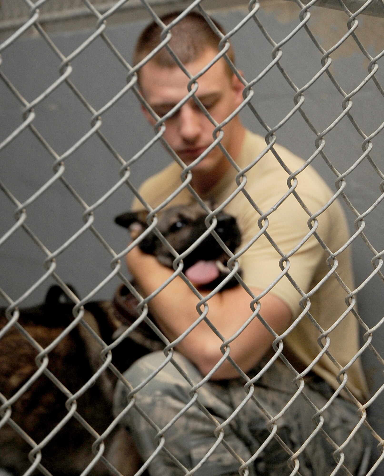Senior Airman Andrew Phillips, 2nd Security Forces Squadron Military Working Dog handler, spends some time with Rico before the canine's feeding time on Barksdale Air Force Base, La., Aug. 24. Though they work as a MWD unit, the handlers and their canines respond to normal patrol calls across the base. The canines here are either trained in explosive or narcotics detection. (U.S. Air Force photo/Senior Airman Amber Ashcraft) (RELEASED)