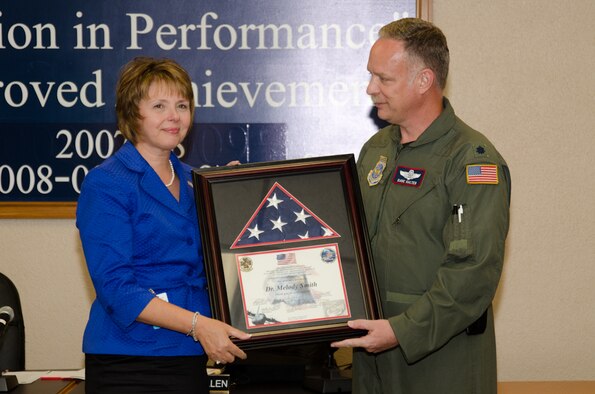 Lt. Col. David Halter, 139th Airlift Wing, Missouri Air National Guard, presents Dr. Melody Smith, Superintendent of the Saint Joseph School District, with a flag that was flown on a combat mission in Afghanistan, on August 22, 2011 in Saint Joseph, Mo. In addition to the flag Dr. Smith received the ESGR “Patriot Award”, and the “Above and Beyond Award” for her support of military families. ( U.S. Air Force Photo by Senior Airman Sheldon Thompson)