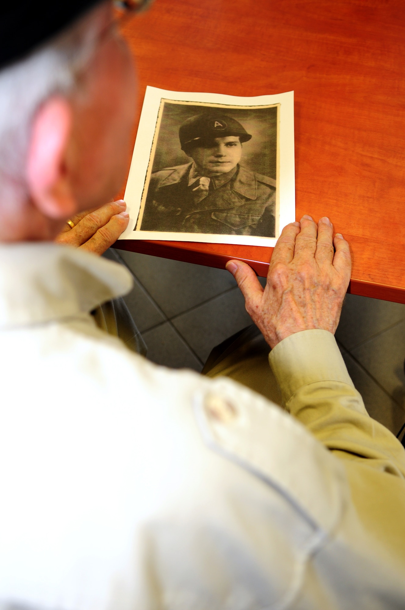 SPANGDAHLEM AIR BASE, Germany – Maurice Sperandieu, a Belgian World War II veteran, looks at a photograph of himself Aug. 23 taken while serving in the Belgian army and assigned the U.S. Army during World War II.  Sperandieu came to Spangdahlem with members of a Belgian WWII honor guard team that partners with the 52nd Fighter Wing Honor Guard for joint events throughout Europe. Sperandieu encouraged today’s Airmen to remember the sacrifices of those who were killed in battle and recognize the cost of freedom. (U.S. Air Force photo/Airman 1st Class Matthew B. Fredericks)